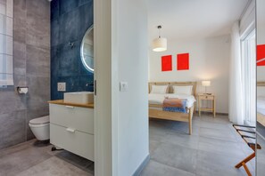Ein modernes Badezimmer mit Toilette, Waschbecken und Spiegel.