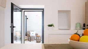 A modern kitchen with a white countertop, a green kettle, and a bowl of fruit. - Spring - The Fab Stay (Ostuni)