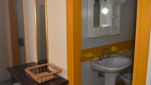 Un baño con encimera de madera, un lavabo blanco y un espejo sobre el lavabo.