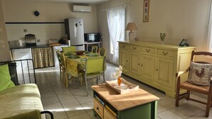 Un espace de vie compact comprenant un coin repas, une cuisine et un coin salon.