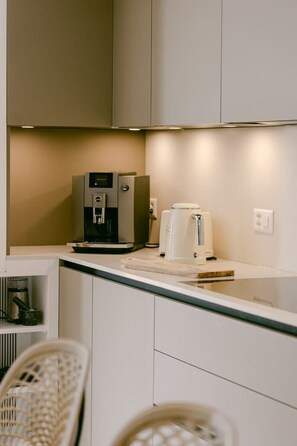 A kitchenette with a coffee maker, a water dispenser, and a toaster. - Millihaus by HomeFlow Zermatt (Zermatt)
