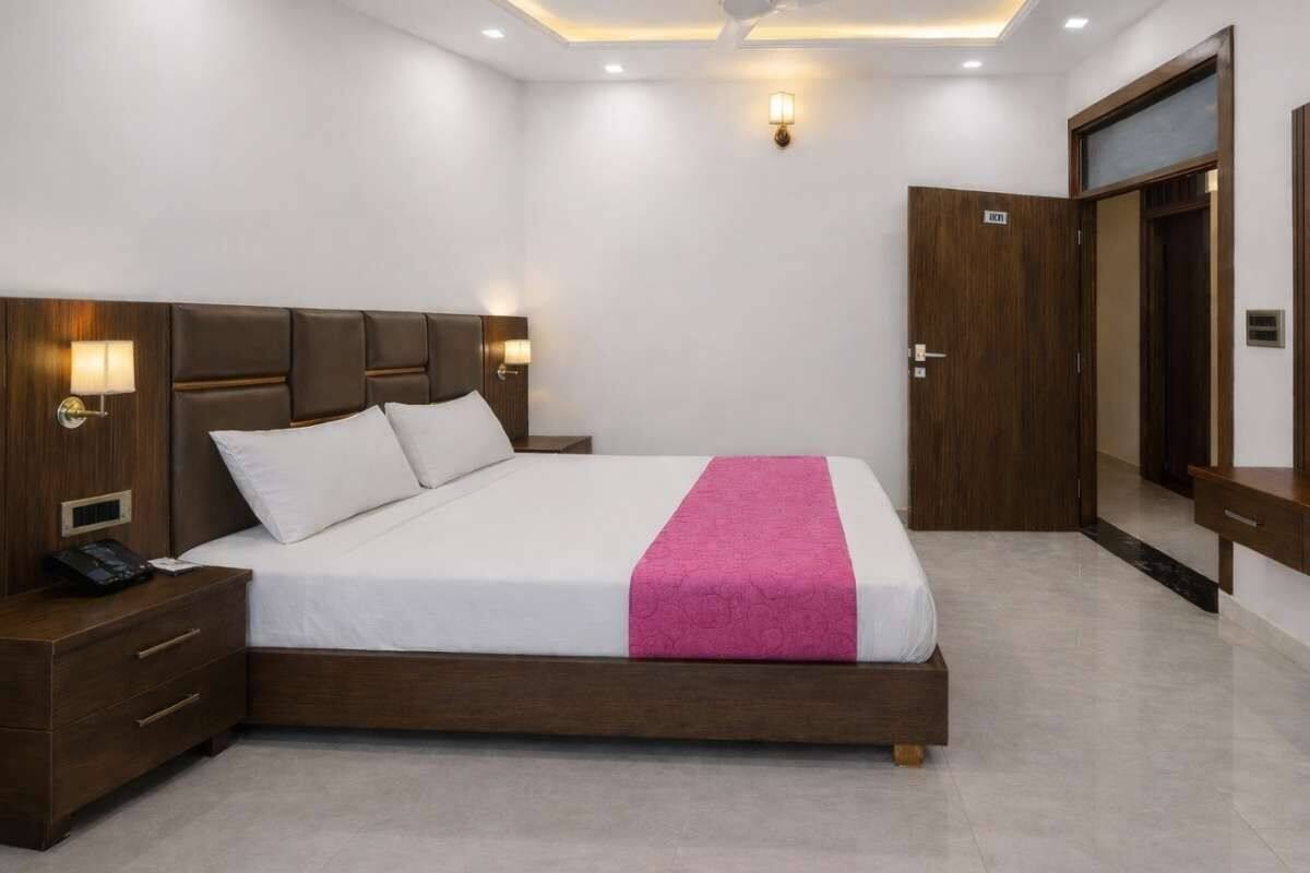 Une chambre d’hôtel avec un grand lit, des lampes de chevet, une télévision et une armoire en bois.