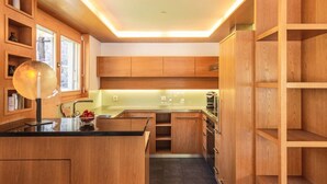 Una cocina moderna con armarios de madera, una isla central y electrodomésticos integrados.