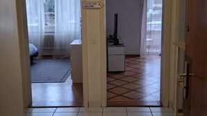 A spacious hallway with a tiled floor, a ceiling light, and a sign indicating a welcome area. - Private Ideal Apartment - Perfectly central to Fribourg. (Fribourg)