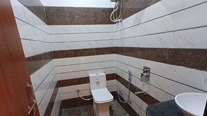 A bathroom with a toilet, sink, and shower. - Hotel JMM Mount View (Udaipur)