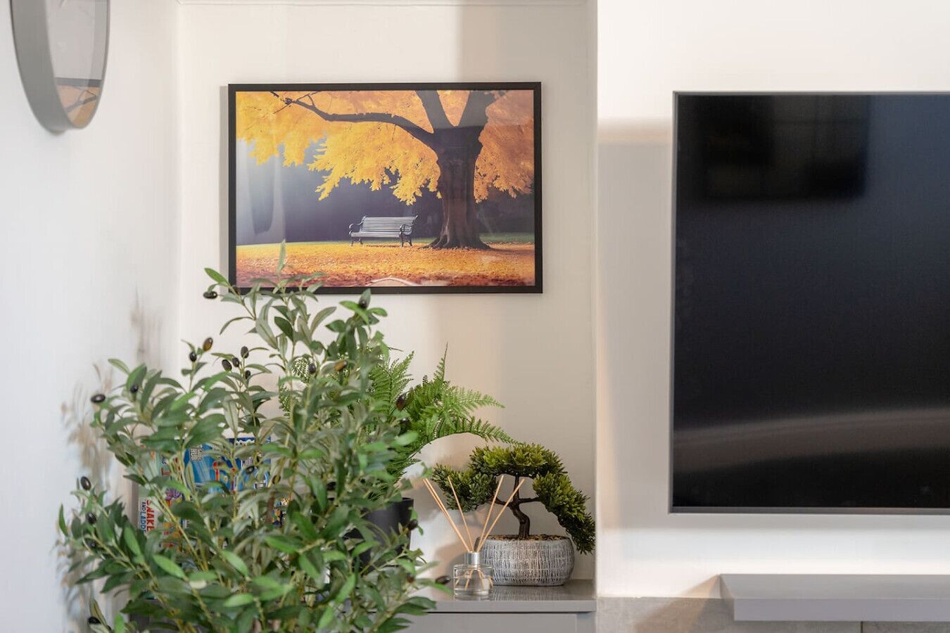Lounge detail with greenery and wall art near the TV area.