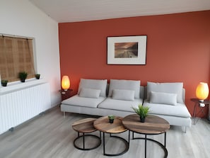A modern living room with a sofa, two round wooden tables, and two floor lamps. - Ô'wazo – Charming House with Pool, 150 m from Beach, 50 m from Shops (Lanton)