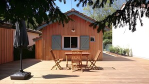 Un bâtiment en bois doté d’un balcon, d’une table avec des chaises et d’un ventilateur de plafond.