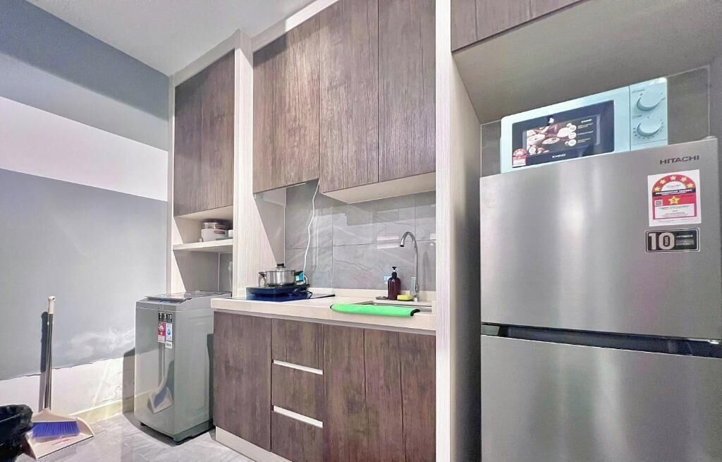 Una cocina moderna con armarios de madera, un refrigerador de acero inoxidable y un microondas.