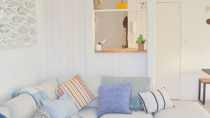 Ein modernes Wohnzimmer mit einer Couch, einem Couchtisch und einer Hängeleuchte.