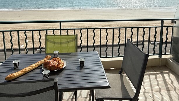 A balcony with a table set for breakfast, overlooking a beach. - Face mer à La Baule : Le Neptune (La Baule-Escoublac)