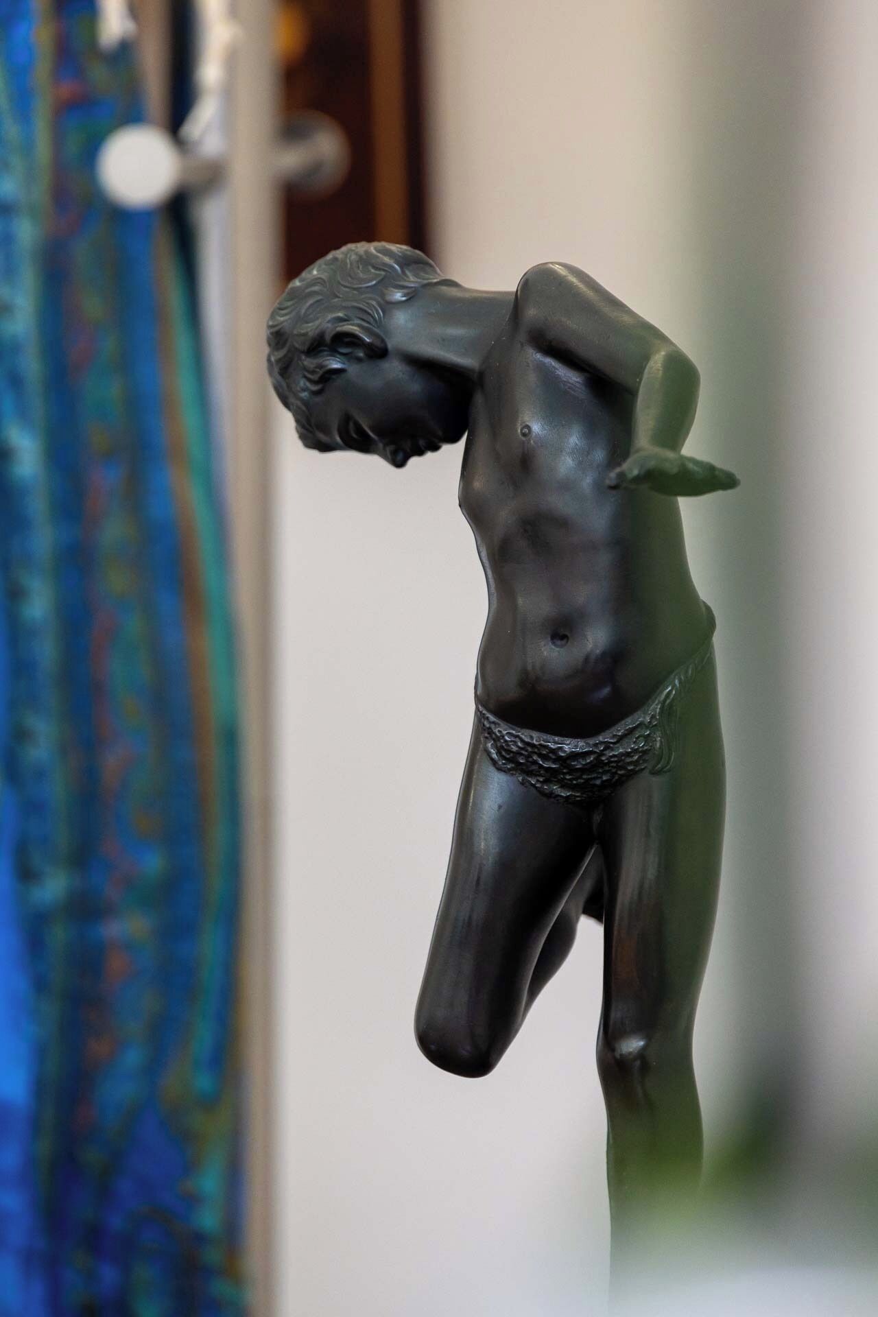Une sculpture représentant une figure musclée dans une pose dynamique, probablement inspirée d’un thème classique ou mythologique.