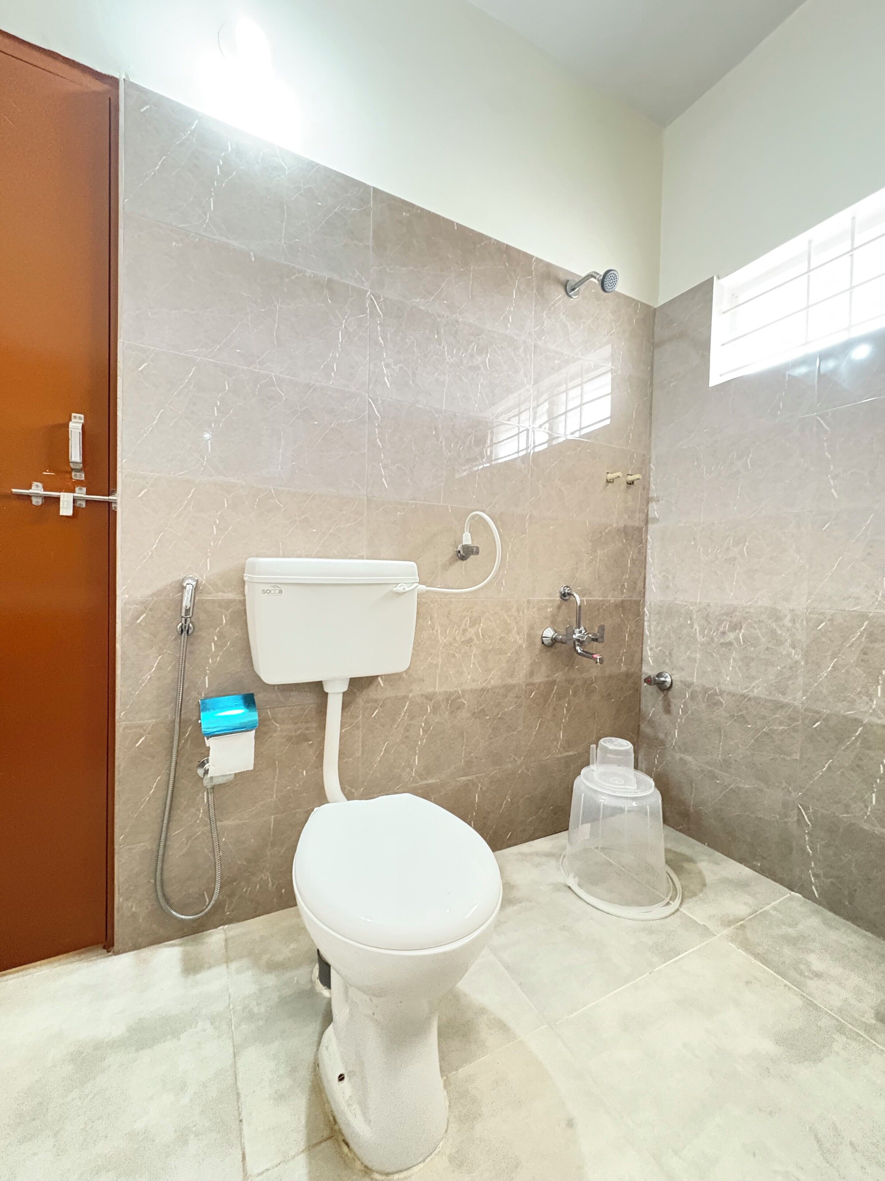 A bathroom with a toilet, a shower, and a sink.