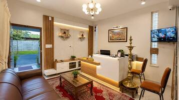 A modern living room with a sofa, a coffee table, and a reception desk.