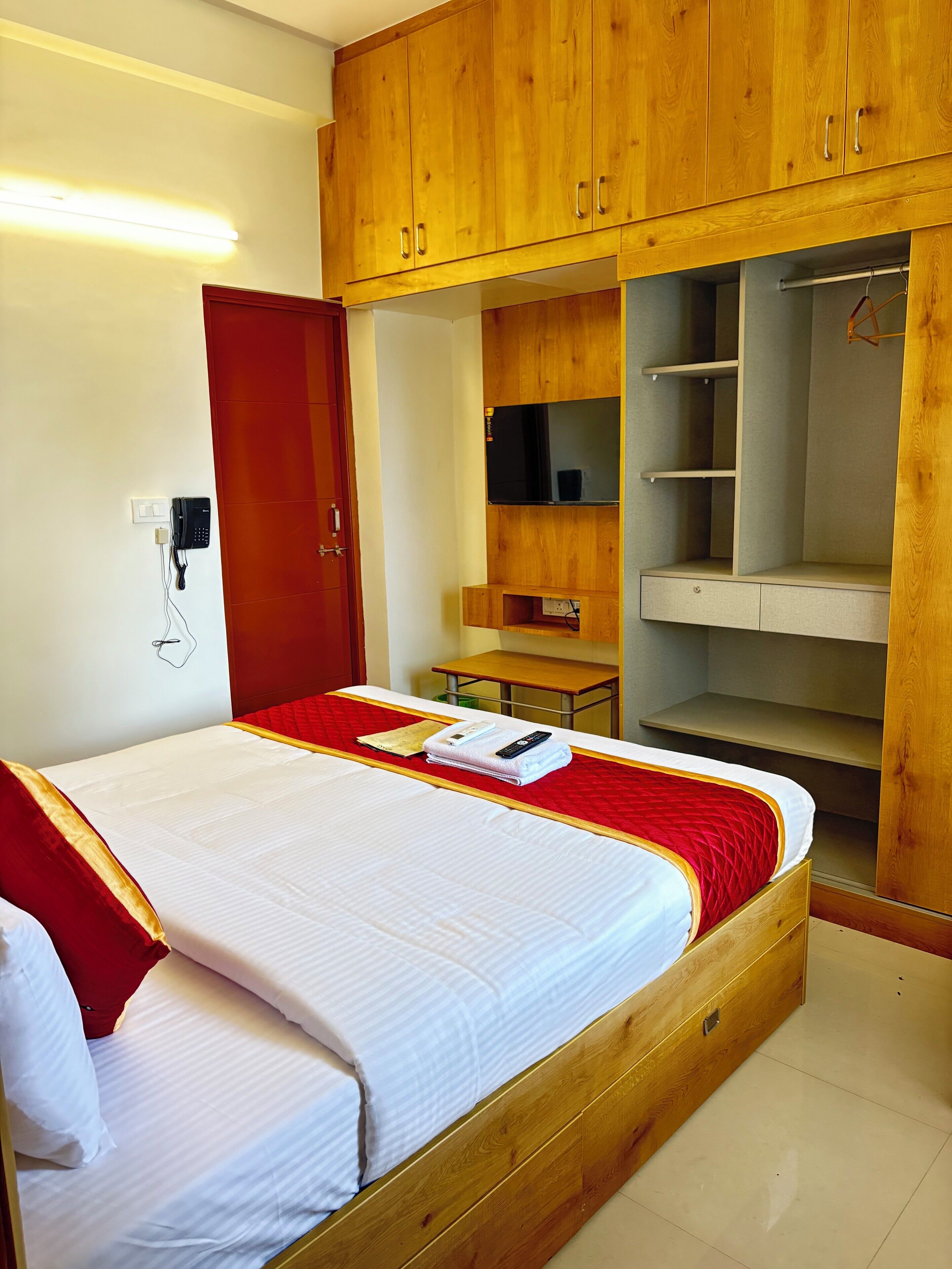 Ein Hotelzimmer mit Bett, Holzschrank und Schreibtisch.