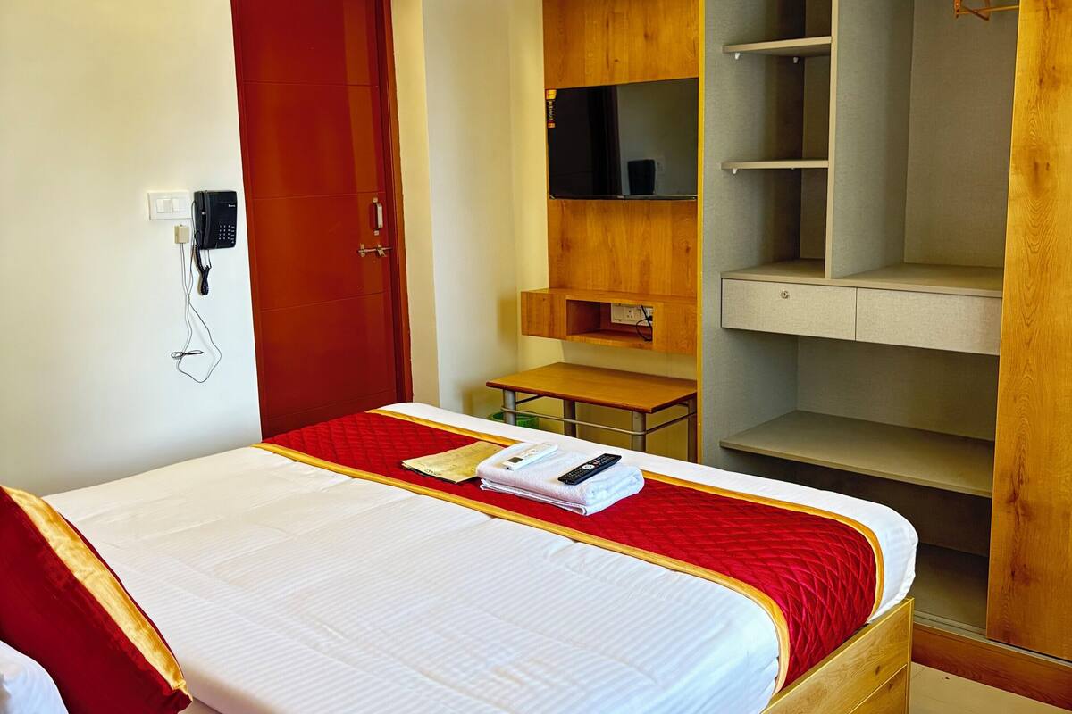 Ein Hotelzimmer mit Bett, Holzschrank und Schreibtisch.