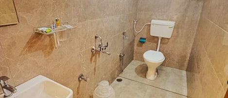 A bathroom with a sink, toilet, shower, and a large water container.