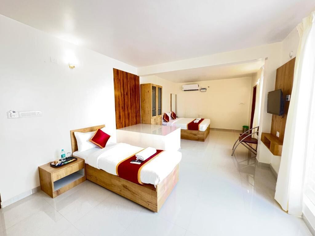 Une chambre d’hôtel avec deux lits, une tête de lit en bois, une table de chevet avec un plateau, un miroir et une télévision.