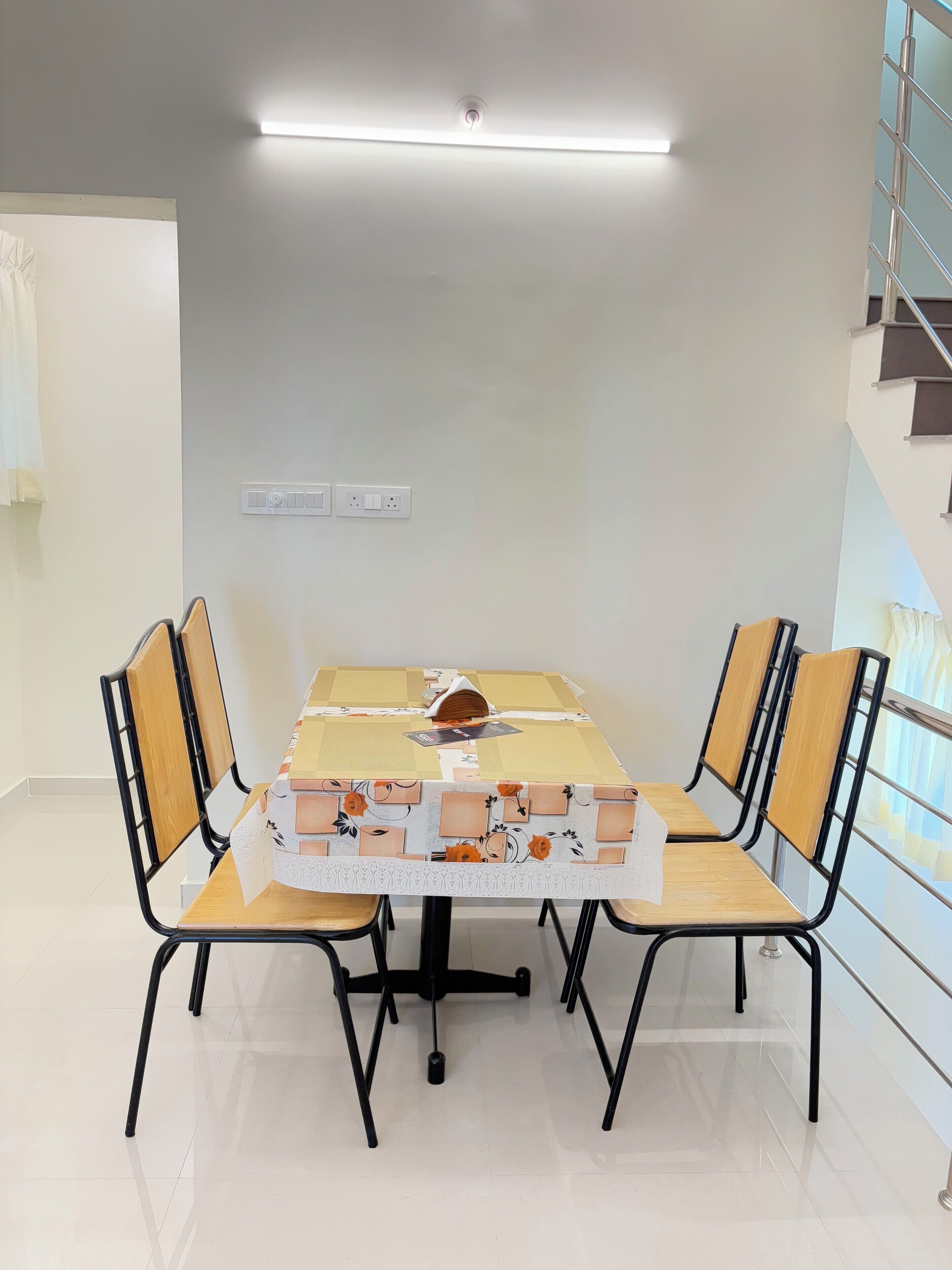 A conference room with a rectangular table, four chairs, and a ceiling light.