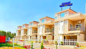 Un hôtel comprenant plusieurs villas, chacune dotée d’un balcon et d’un espace de réception.