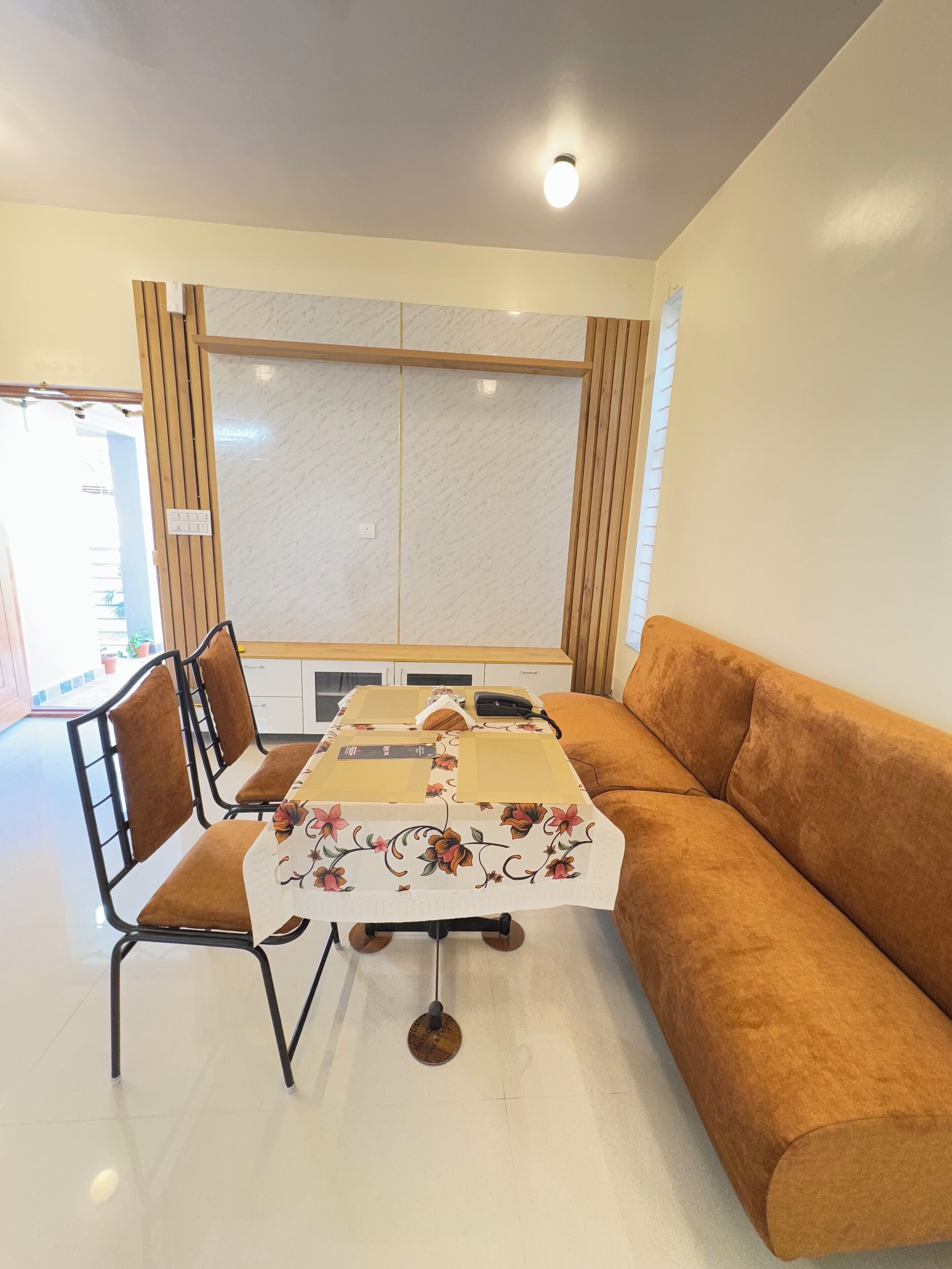 Una sala de estar moderna con un sofá, una mesa de comedor con sillas y una cocina al fondo.