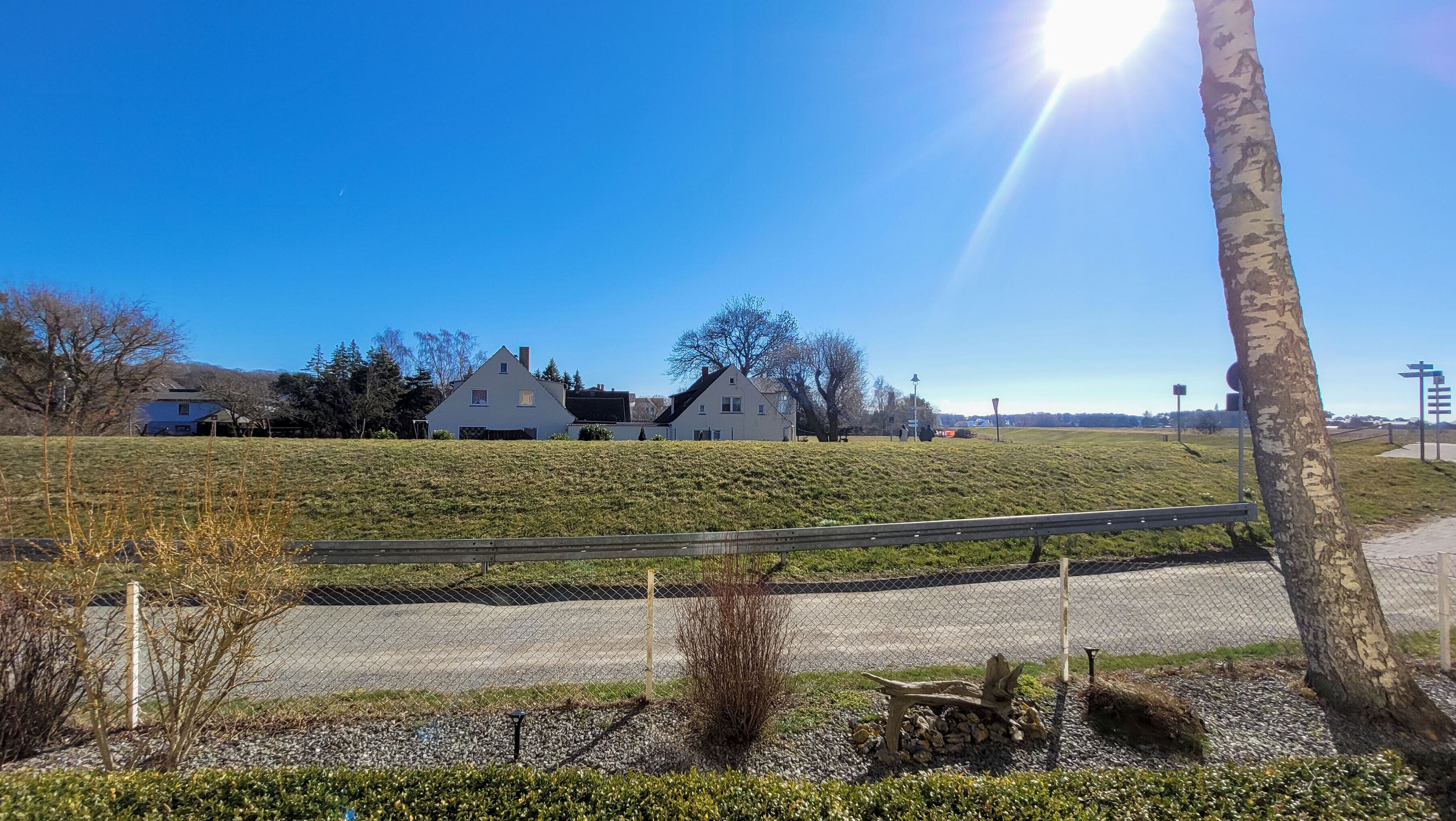 A house on a grassy hill with a clear sky.