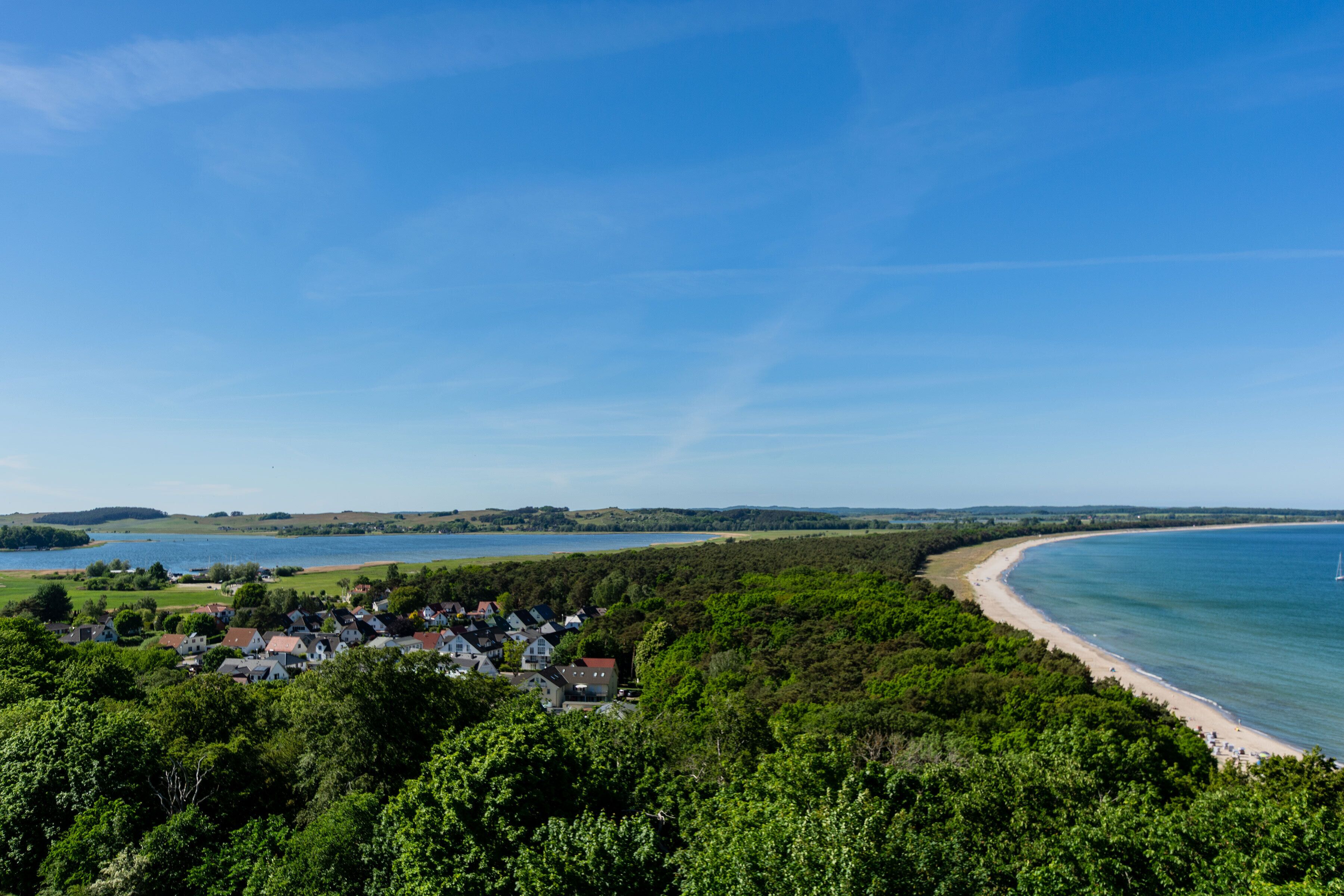 A coastal village with houses, a beach, and a body of water.