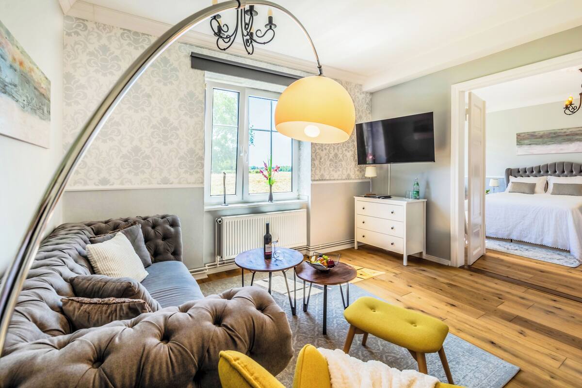 Un dormitorio moderno con una cama grande, un televisor, un sofá y un comedor.