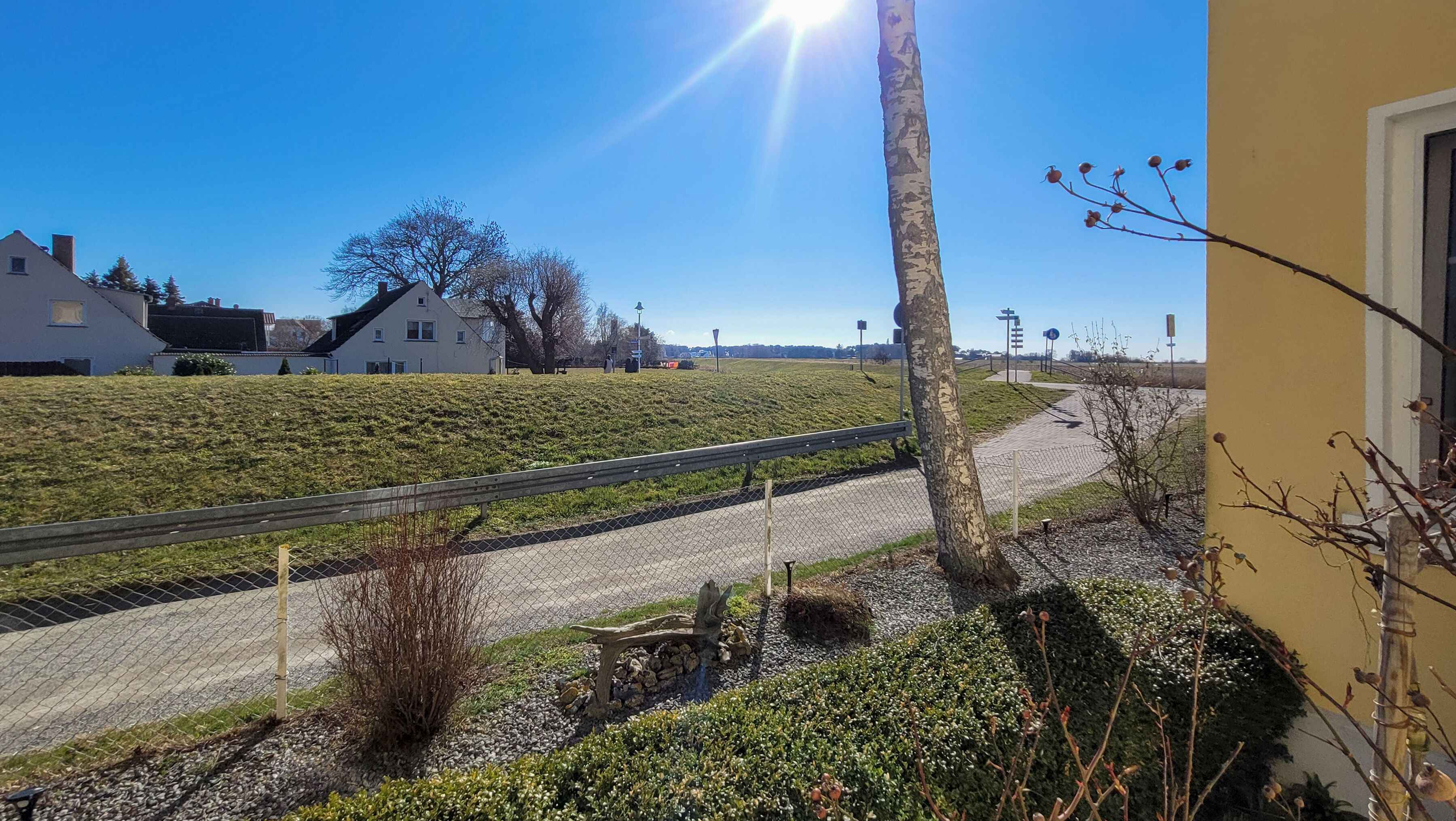 Ein Wohngebiet mit Häusern, blauem Himmel und einem Zaun.