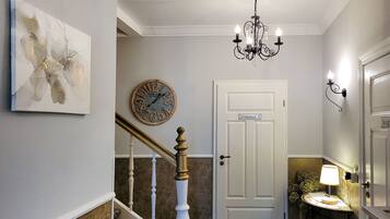 A staircase with a white door labeled 'Zimmer' and a wall clock.