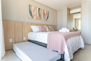 Une chambre à coucher moderne avec un grand lit, une tête de lit en bois et un climatiseur fixé au mur.