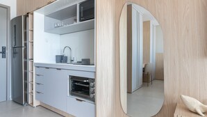 Une cuisine moderne équipée d’un four encastré, d’un évier et d’un grand miroir.