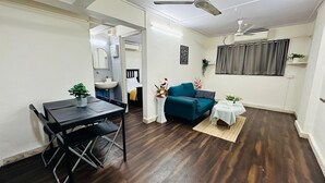 Ein gemütlicher Wohnbereich mit Essplatz, einer Couch, einem kleinen Tisch und einem Deckenventilator.