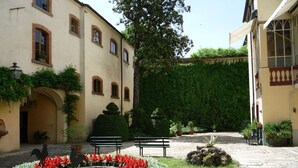 A courtyard with a circular flower bed, benches, and a hedge wall. - Beautiful private villa for 6 people with WIFI, private pool, TV, patio and panoramic view (Tredozio)