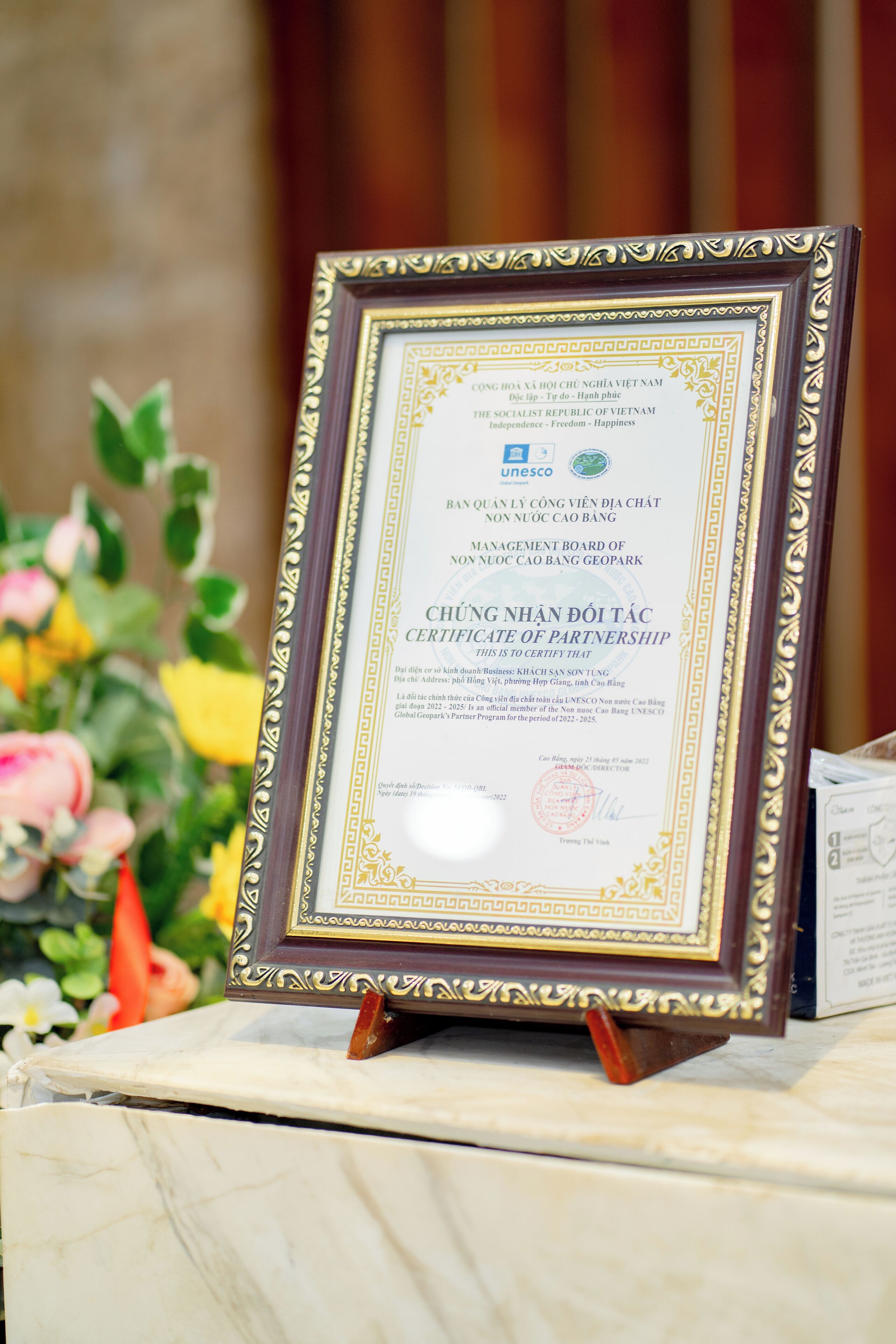 A framed certificate of partnership on a marble table.