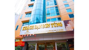 A hotel entrance with a sign reading "KHÃCH SÃN SÔN TÃNG" and a large glass facade. - Son Tung Hotel - Kim Dong Walking Street (Thuc Phan)