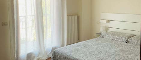 Tabla de planchar con plancha, internet y ropa de cama
