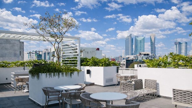 A rooftop terrace with outdoor seating, a pergola, and a view of the city skyline. - Modern loft on Monterrey Street in the heart of Roma Norte. Perfect for up to 3 guests, with a fully equipped kitchen, sofa bed, fast WiFi ideal for remote work, and easy self check-in. Shared rooftop and laundry in the building. Walk to cafés, parks (Cuauhtémoc)
