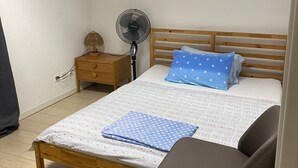 A bedroom with a bed, bedside table, lamp, fan, and a chair. - Peaceful 2-bedroom apartment in charming Balerna perfect for relaxing stays (Balerna)