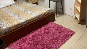 A bedroom with a bed, a desk, a chair, a small wooden shelf, and a fan. - Peaceful 2-bedroom apartment in charming Balerna perfect for relaxing stays (Balerna)