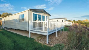 A mobile home with a deck and a fenced yard. - Premium Lodge - Sleeps 8 - Seton Sands Beach (Prestonpans)