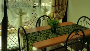 A dining area with a table, chairs, and a potted plant.