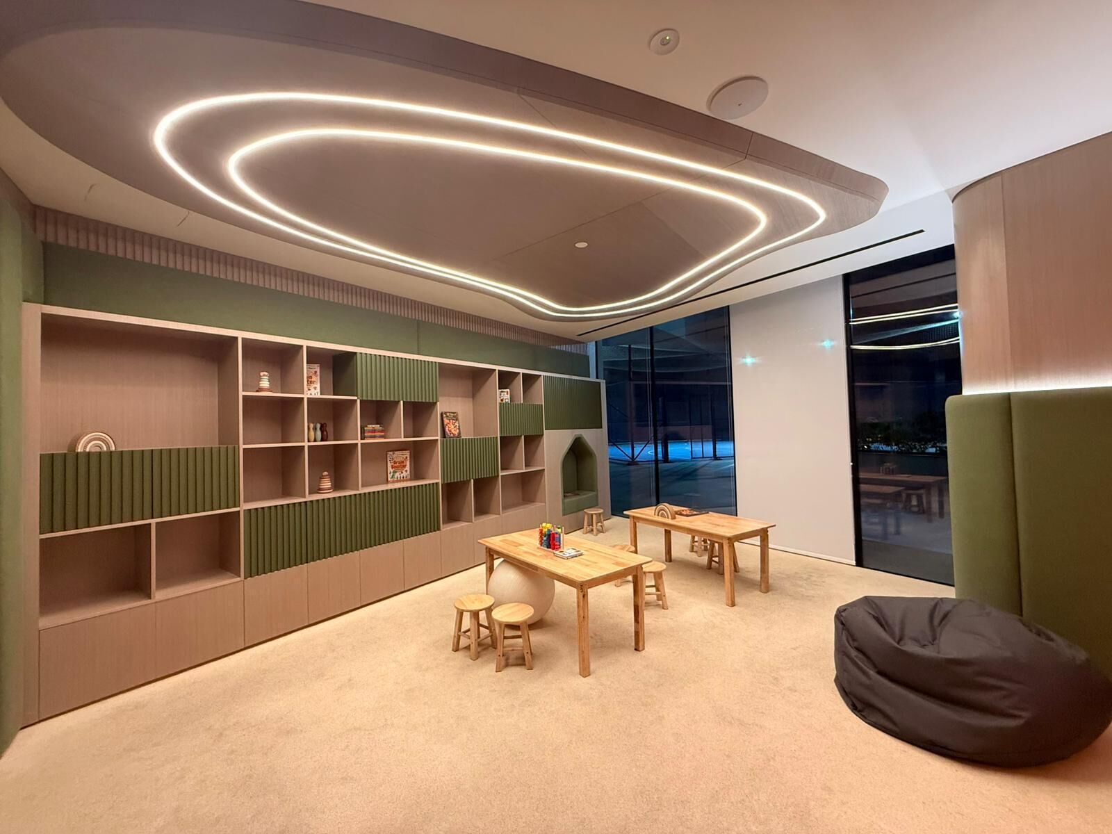 A modern interior with a curved ceiling, built-in shelving, and a seating area with a table and chairs.