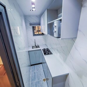 Apartamento família, sacada, vista para a cidade | Cozinha privada | Geladeira, micro-ondas, fogão, cooktop