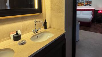 A modern bathroom with a double sink, a large mirror, and a red lamp.