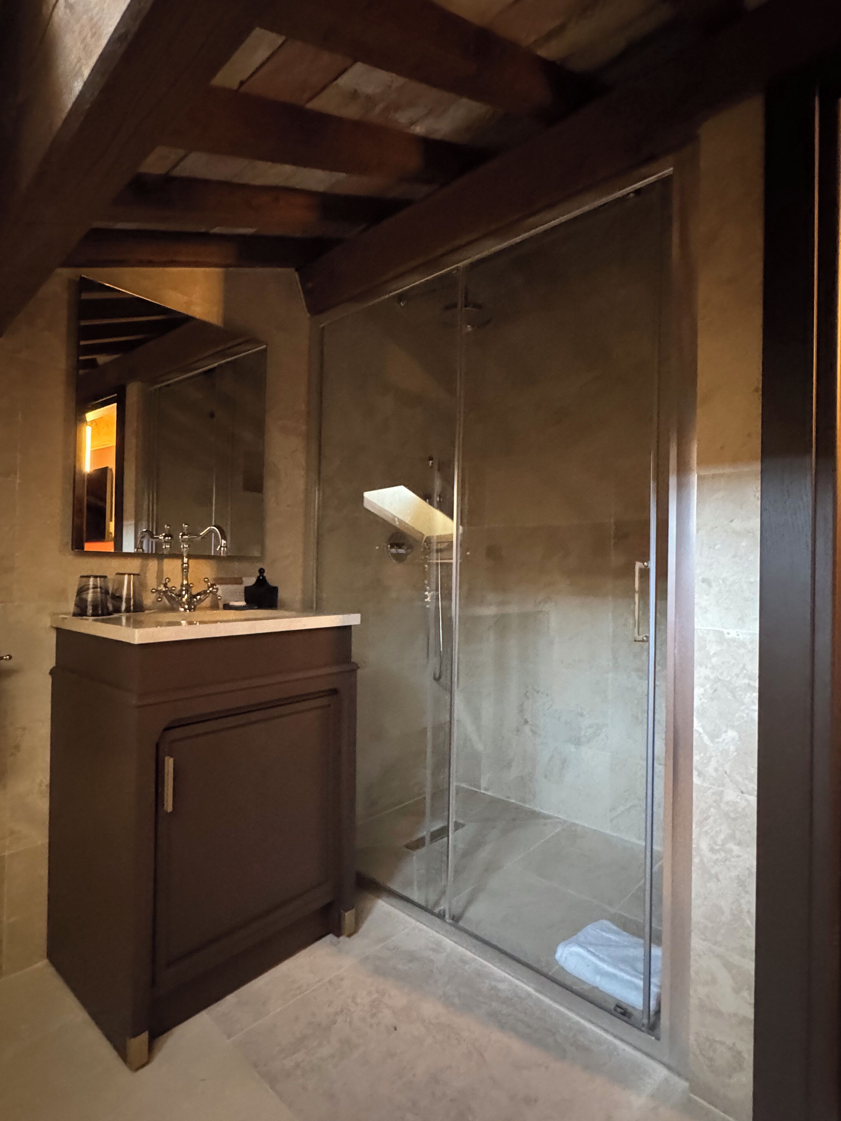 Ein Badezimmer mit Duschkabine, Waschtisch und Spiegel.