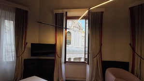A hotel room with a bed, a TV, a chair, and a window with curtains. - Palazzo Gambirasi Aparthotel Roma (Rome)