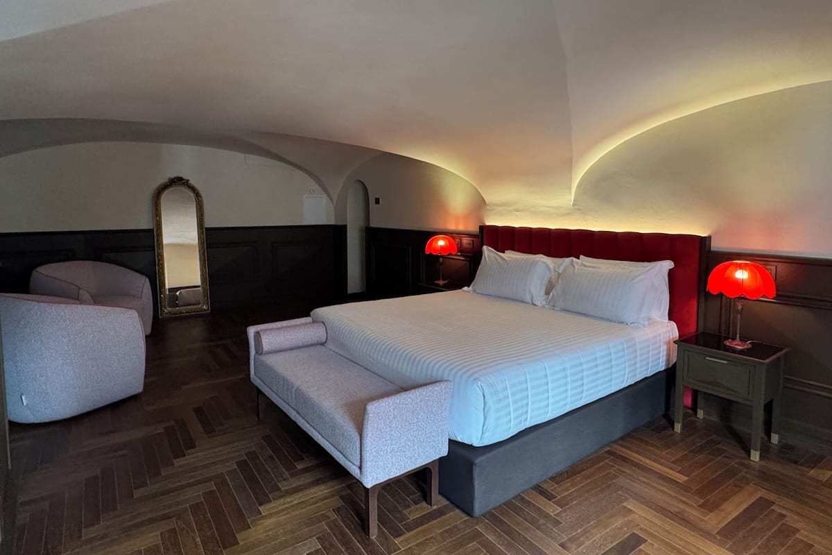 Ein Hotelzimmer mit einem großen Bett, einer Sitzecke und einem Spiegel.