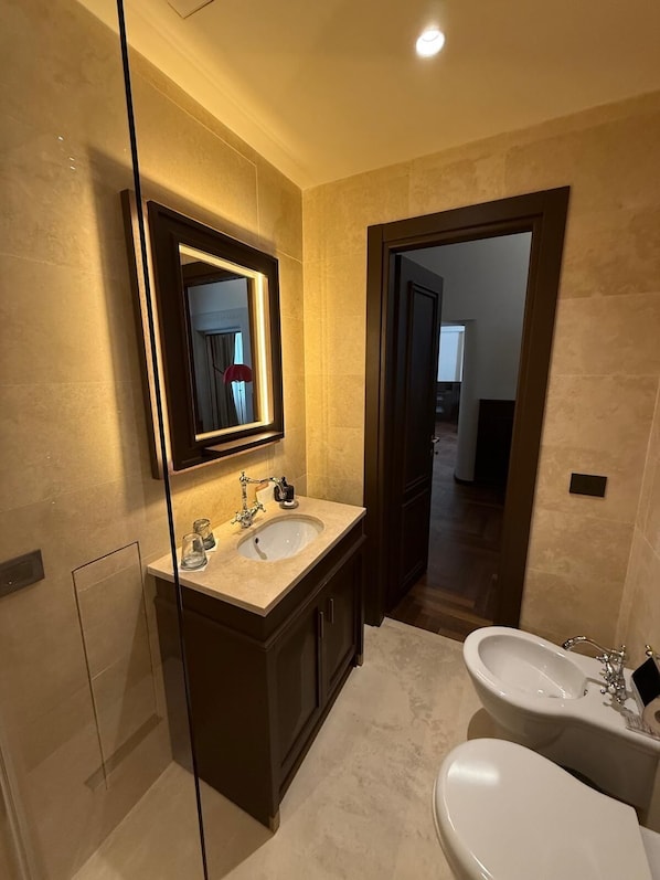 A modern bathroom with two sinks, a large mirror, and a bidet. - Palazzo Gambirasi Aparthotel Roma (Rome)