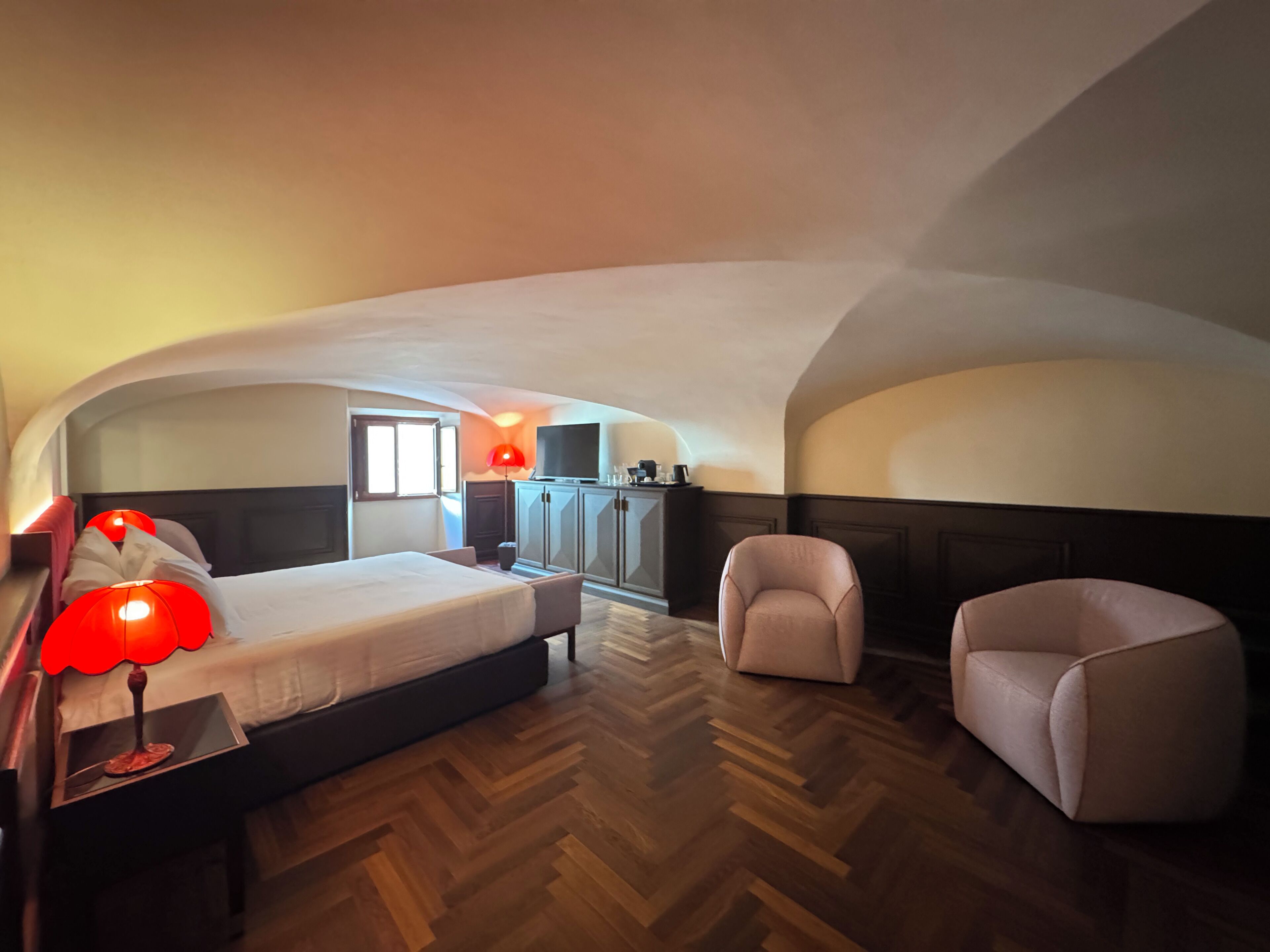 Una habitación de hotel con cama, escritorio, silla y televisión.